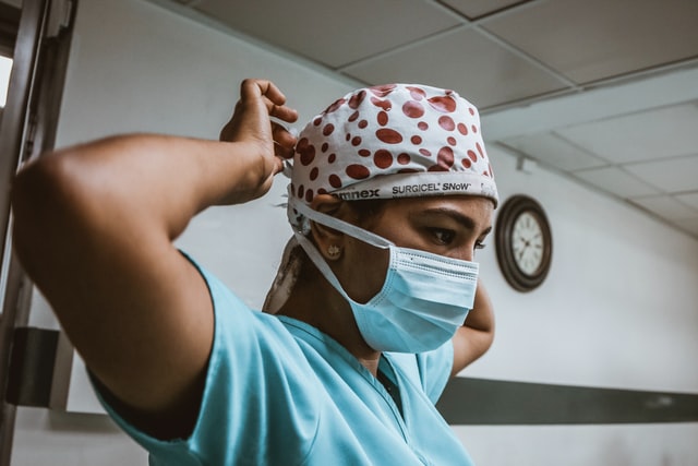 black medical worker putting on face mask