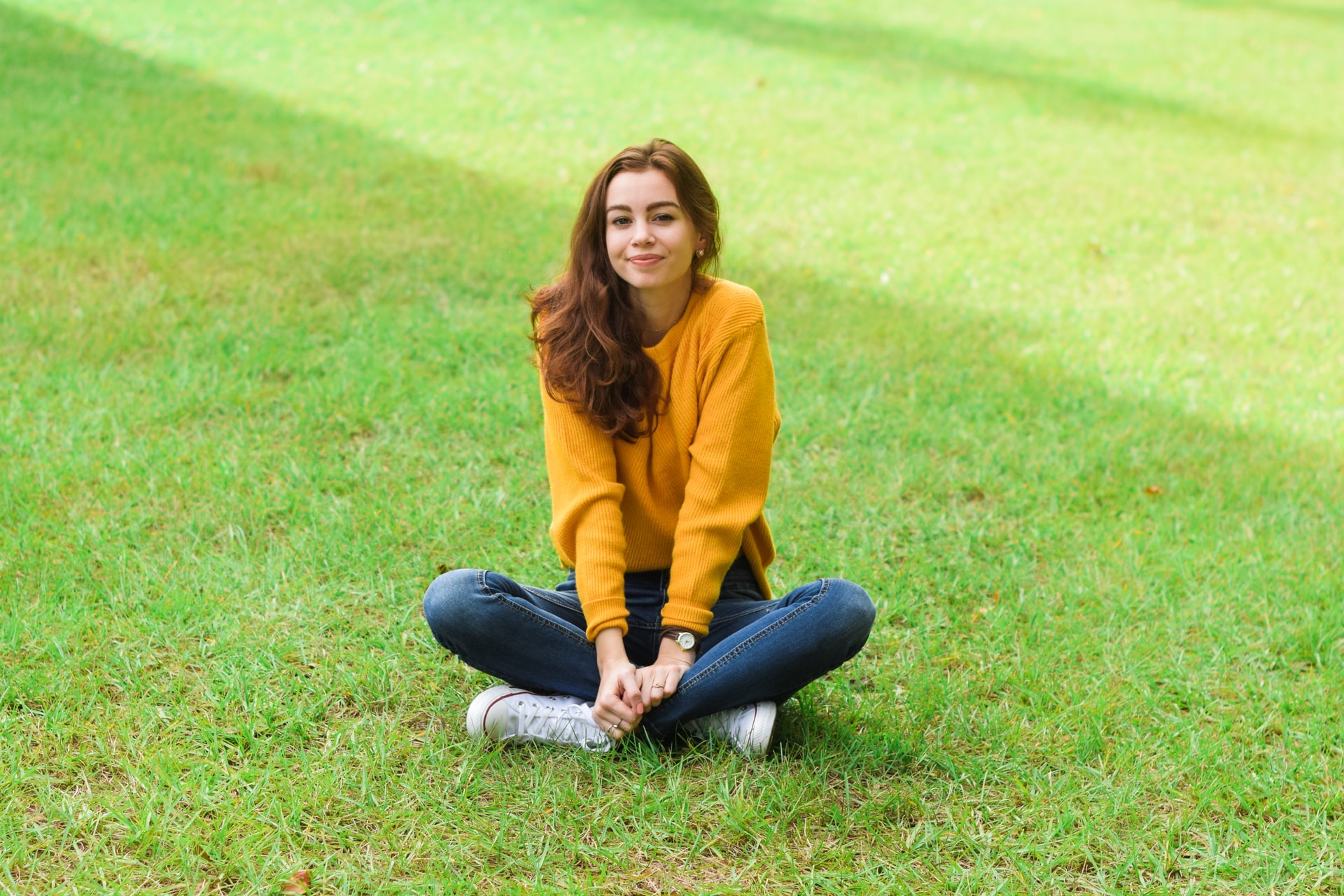 young woman sitting on grass