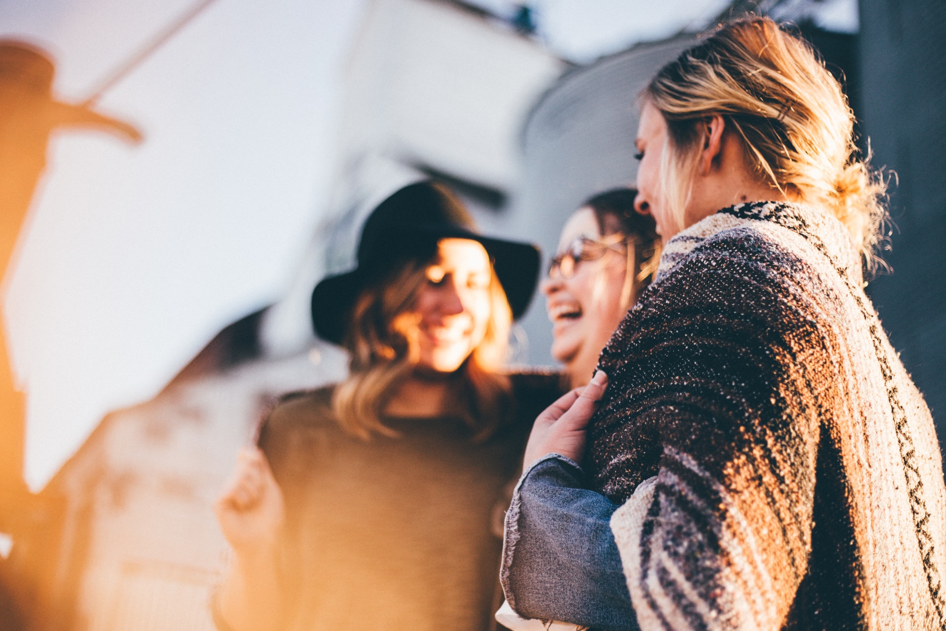 three women standing in a circle laughing